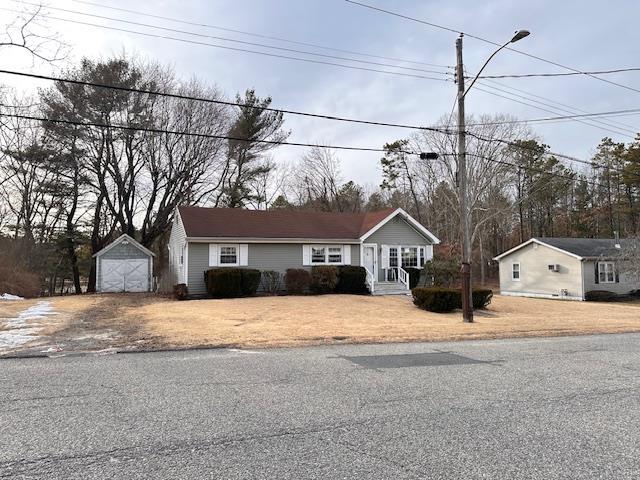 view of front facade featuring a detached garage and an outbuilding