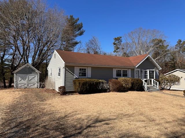 view of front of home featuring a garage, an outdoor structure, and a shed