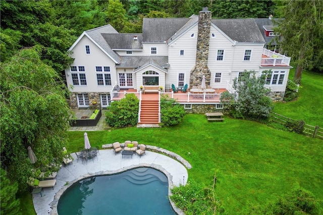 back of house with a chimney, stairway, a lawn, and a wooden deck