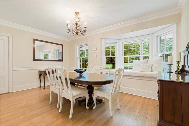 dining room with light wood-type flooring, baseboards, ornamental molding, and a chandelier