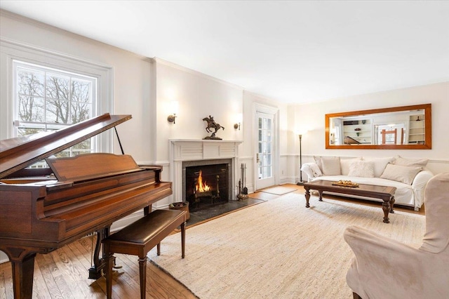 living room featuring a warm lit fireplace and wood-type flooring