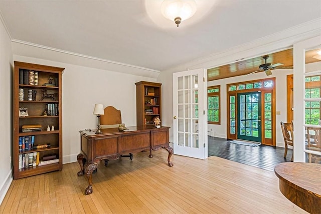 home office with french doors, baseboards, crown molding, and hardwood / wood-style floors