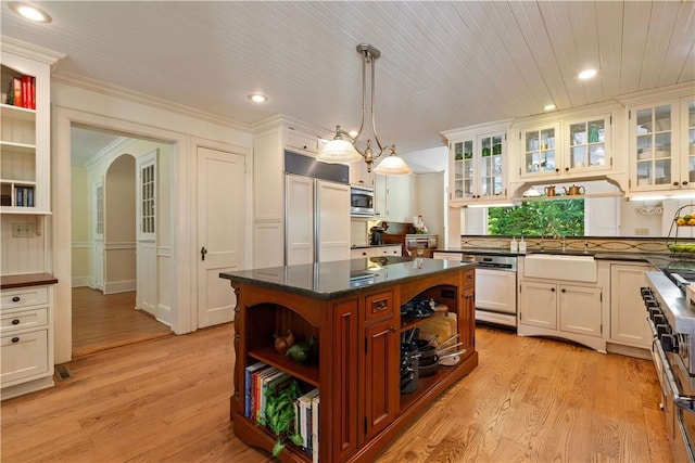 kitchen with built in appliances, arched walkways, a sink, light wood-style floors, and open shelves