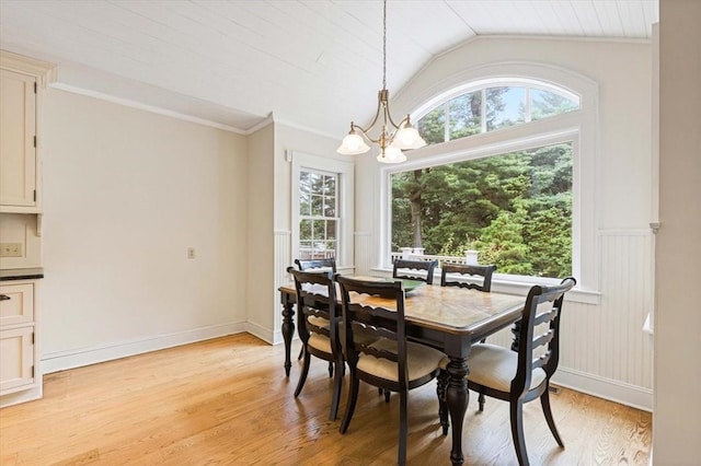 dining room featuring a chandelier, vaulted ceiling, ornamental molding, wainscoting, and light wood-type flooring