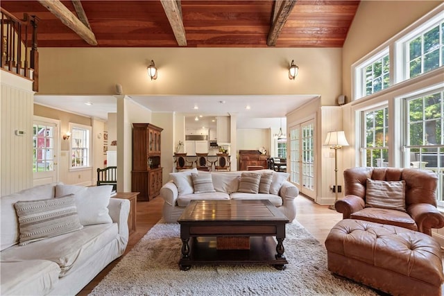 living area featuring high vaulted ceiling, wood ceiling, light wood-style flooring, and beam ceiling