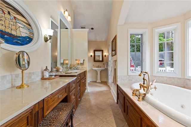 full bathroom featuring a jetted tub, tile patterned flooring, baseboards, and a sink