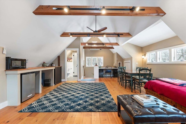 living area with lofted ceiling with beams, wood-type flooring, and a ceiling fan