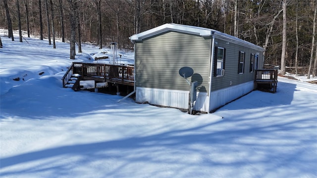 view of snowy exterior featuring a wooden deck