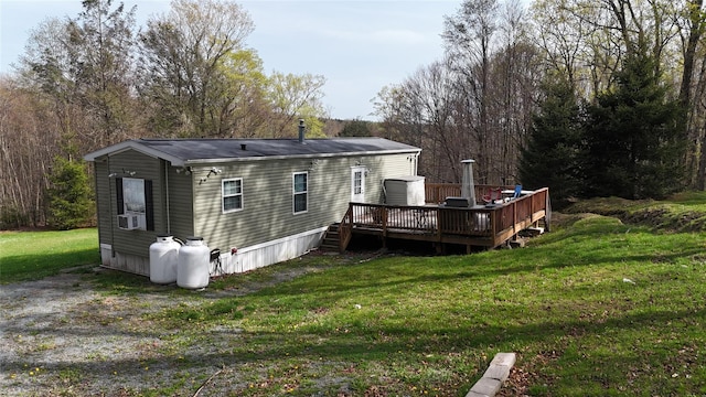 back of house featuring a lawn and a deck