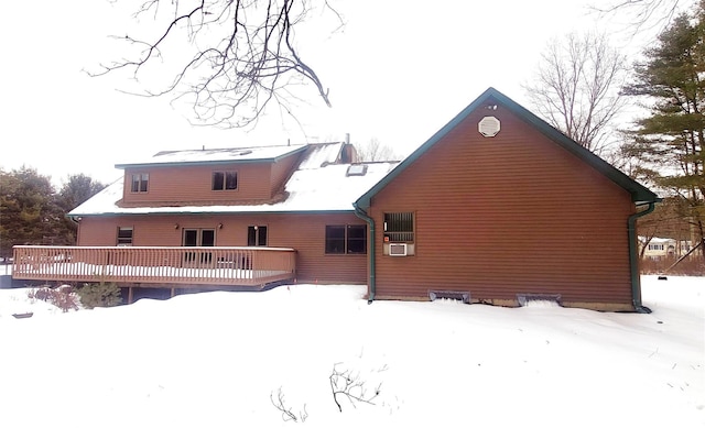 snow covered back of property featuring a wooden deck