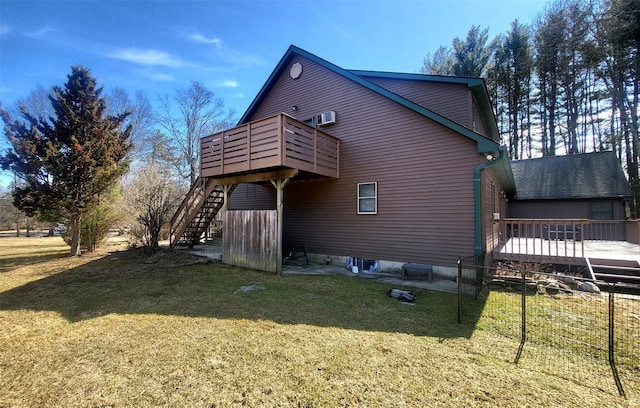 rear view of property featuring stairway, a lawn, and a deck