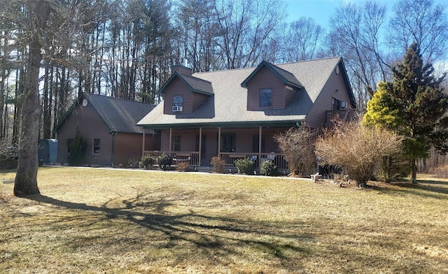 view of front of home with a porch, a front yard, roof with shingles, and a chimney