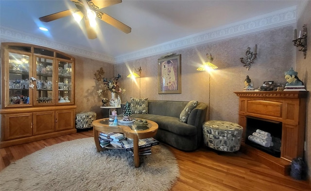 living room with wallpapered walls, wood finished floors, and ornamental molding