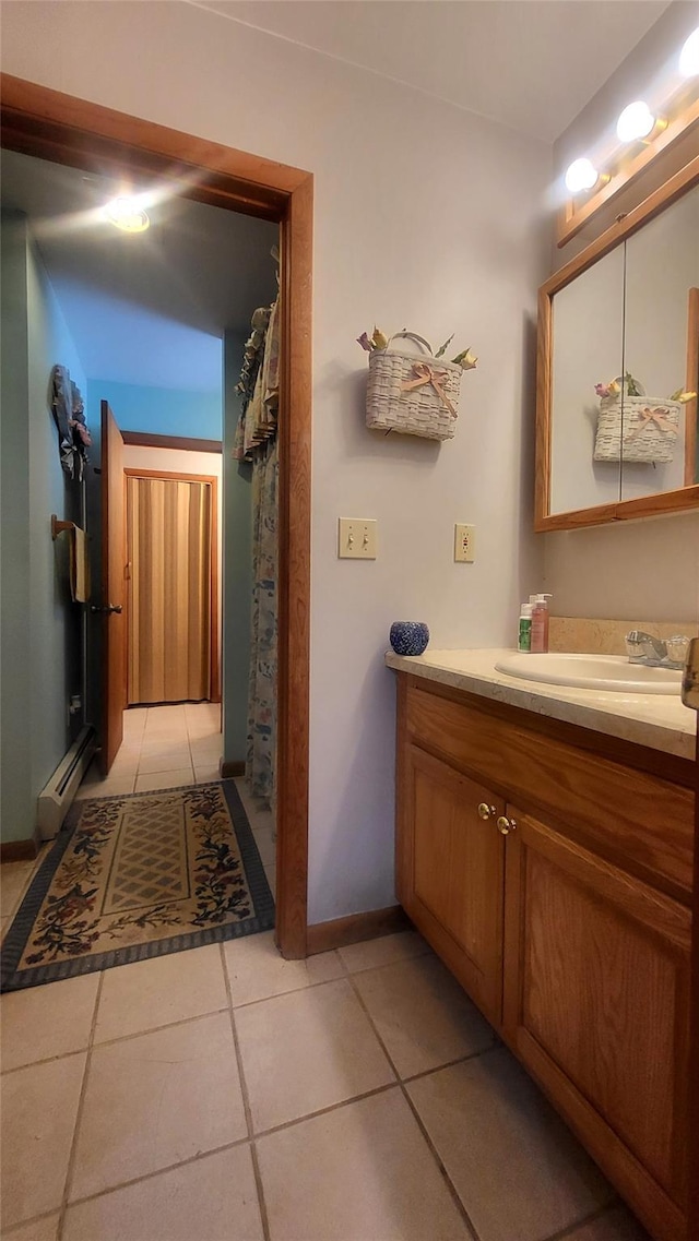 bathroom featuring tile patterned flooring, vanity, baseboards, and a baseboard radiator