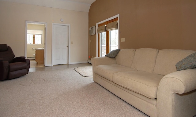carpeted living area with lofted ceiling, baseboards, a baseboard heating unit, and a wall unit AC