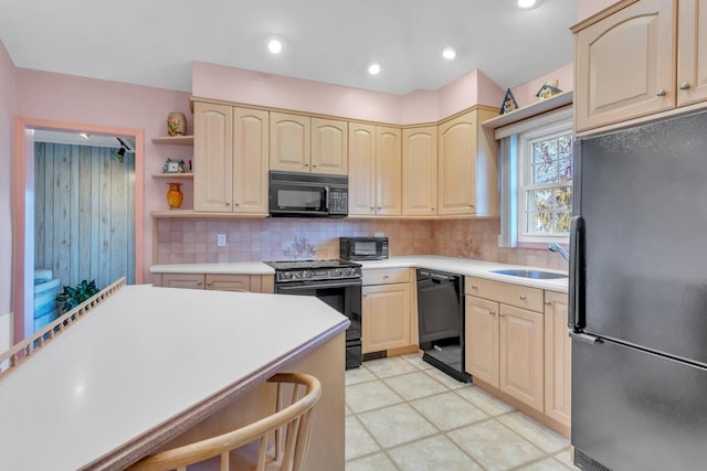 kitchen with sink, black appliances, light brown cabinetry, and decorative backsplash