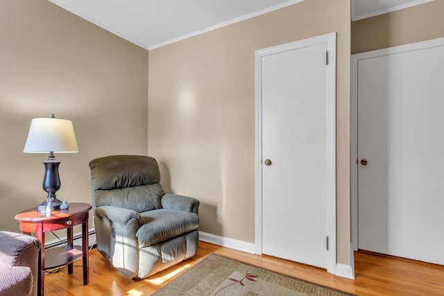 sitting room with wood-type flooring and ornamental molding