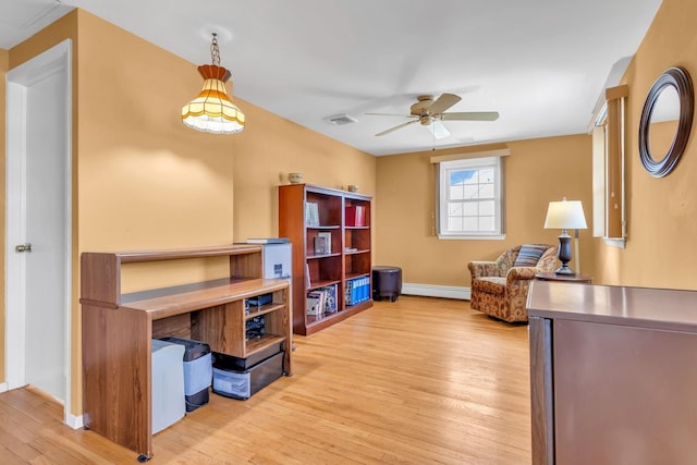 home office with light wood-type flooring and ceiling fan