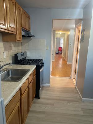 kitchen with stainless steel range with gas cooktop, brown cabinets, a sink, and under cabinet range hood