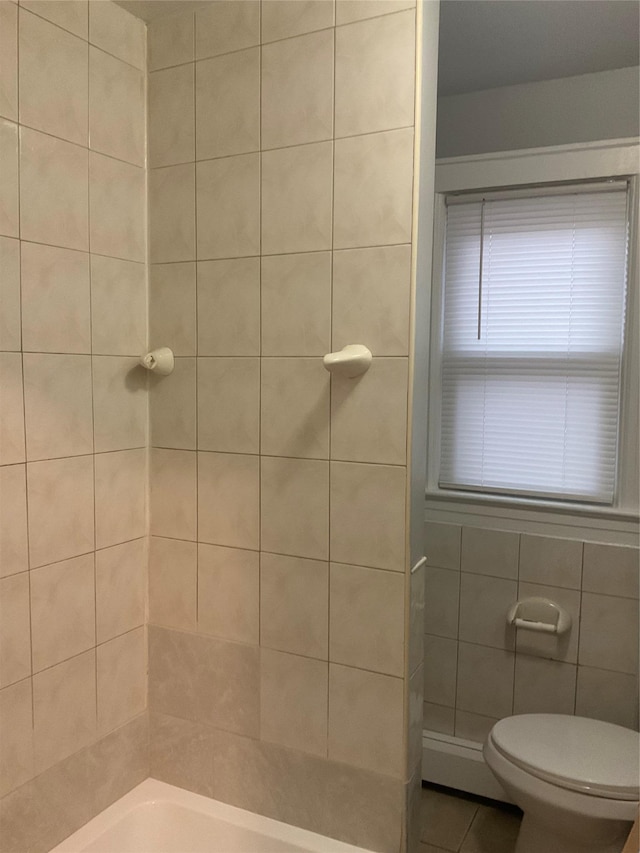 full bathroom with toilet, walk in shower, tile walls, and tile patterned floors
