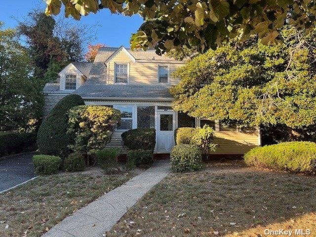 cape cod house with a front yard