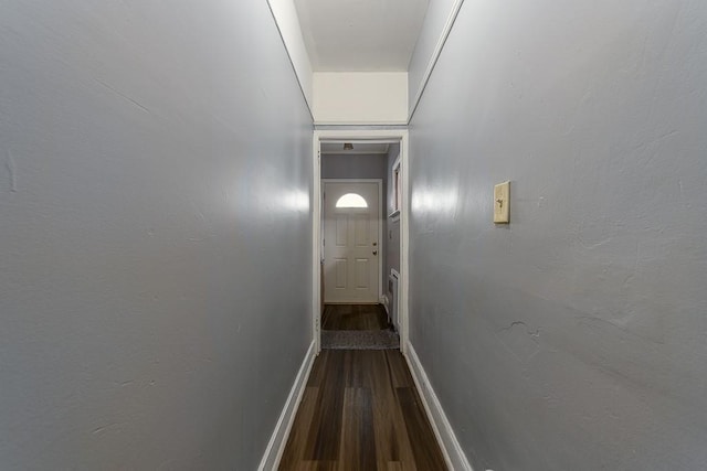 hallway with dark wood-type flooring and baseboards