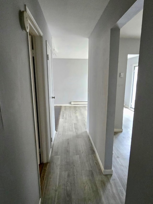 15 Harrison Unit 39E, Amityville, NY 11701 - hallway featuring baseboard heating and light hardwood / wood-style flooring