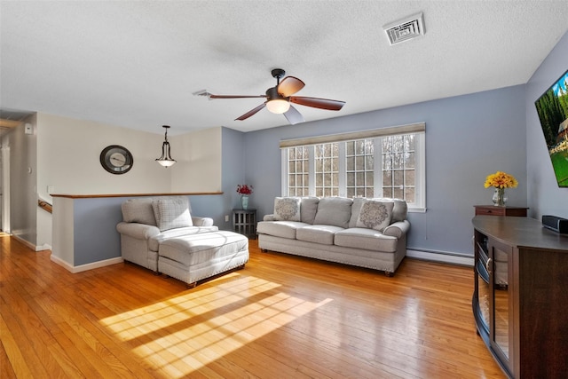 living room featuring a baseboard radiator, a textured ceiling, light wood-type flooring, and ceiling fan