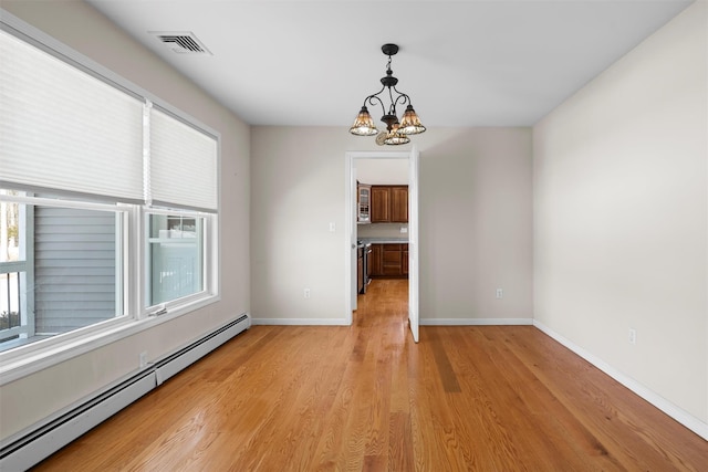 unfurnished dining area featuring a healthy amount of sunlight, a baseboard radiator, visible vents, and a notable chandelier