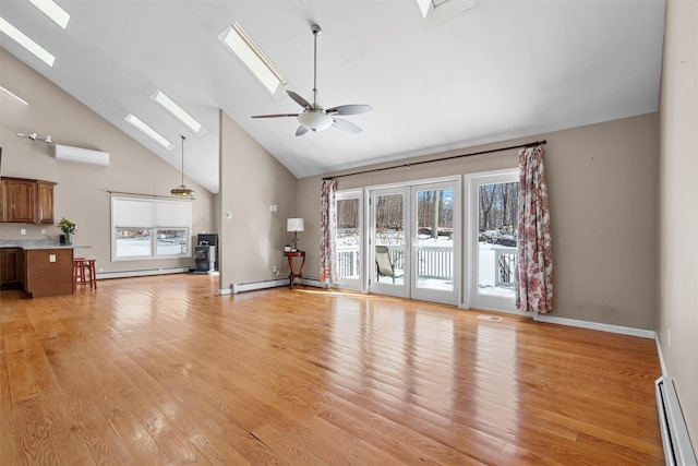 unfurnished living room with a baseboard heating unit, a healthy amount of sunlight, a skylight, and a wall mounted air conditioner