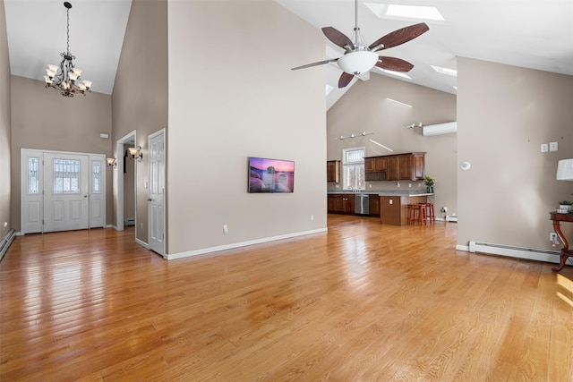 unfurnished living room featuring light wood finished floors, baseboards, a baseboard radiator, a wealth of natural light, and ceiling fan with notable chandelier