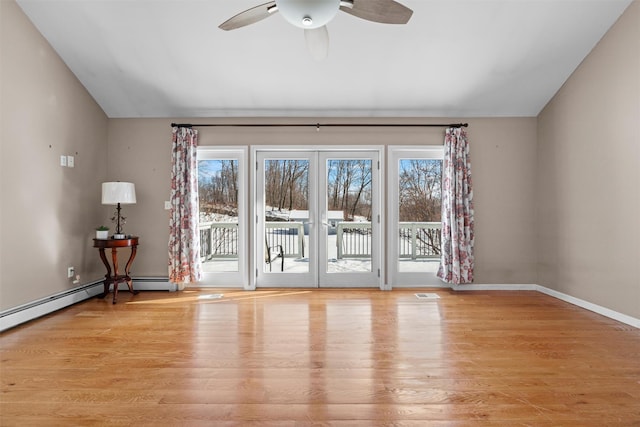 spare room featuring lofted ceiling, visible vents, a ceiling fan, light wood-type flooring, and baseboards