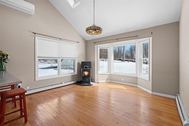 interior space with a wood stove, light wood-style flooring, a wall mounted air conditioner, and a baseboard radiator