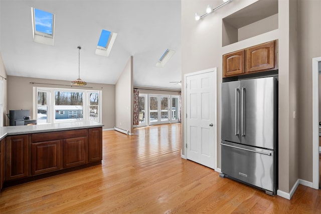 kitchen featuring a healthy amount of sunlight, light countertops, high end fridge, and decorative light fixtures