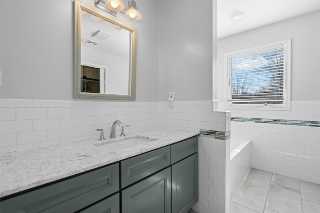 bathroom featuring visible vents, wainscoting, tile patterned flooring, vanity, and tile walls