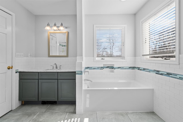 full bath with tile patterned flooring, a garden tub, tile walls, and vanity