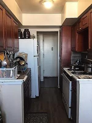 kitchen with dark wood-type flooring, stainless steel gas range, and decorative backsplash