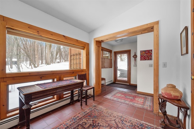 entryway featuring lofted ceiling, baseboard heating, baseboards, and tile patterned floors