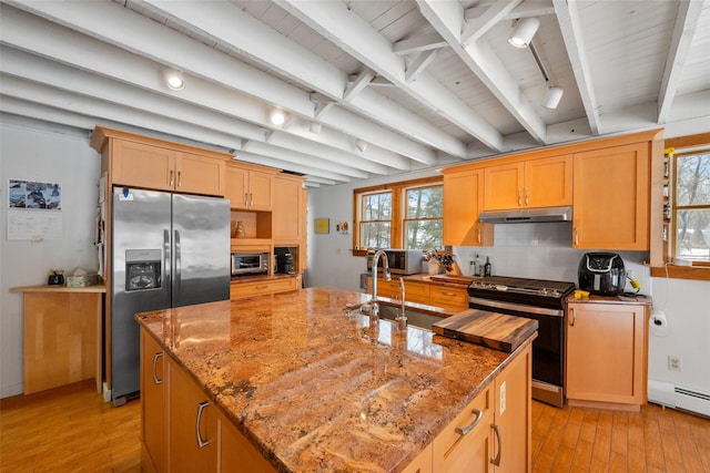 kitchen featuring range with gas stovetop, stainless steel fridge with ice dispenser, a baseboard radiator, under cabinet range hood, and a sink