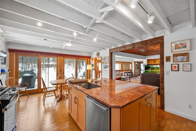 kitchen with a center island with sink, gas stove, a sink, light wood-type flooring, and dishwasher