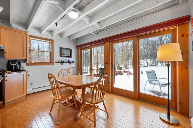 dining room featuring a baseboard heating unit, light wood-type flooring, beam ceiling, and plenty of natural light