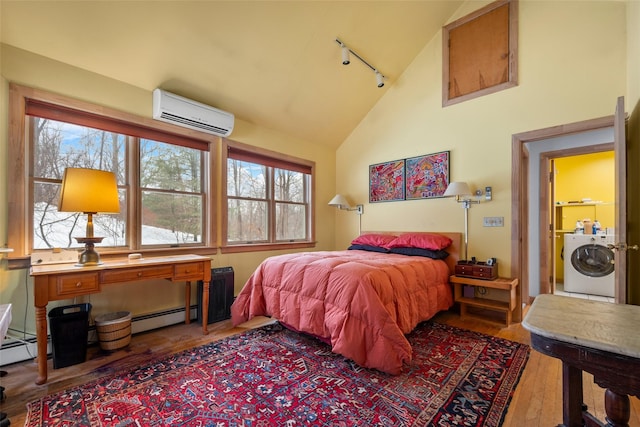 bedroom with a wall unit AC, a baseboard radiator, multiple windows, and washer / clothes dryer