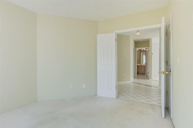 unfurnished room featuring light carpet and light tile patterned flooring