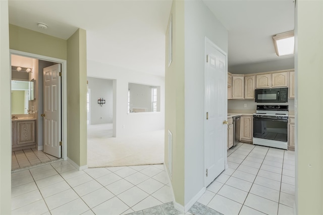 kitchen featuring gas stove, black microwave, light countertops, and light tile patterned floors