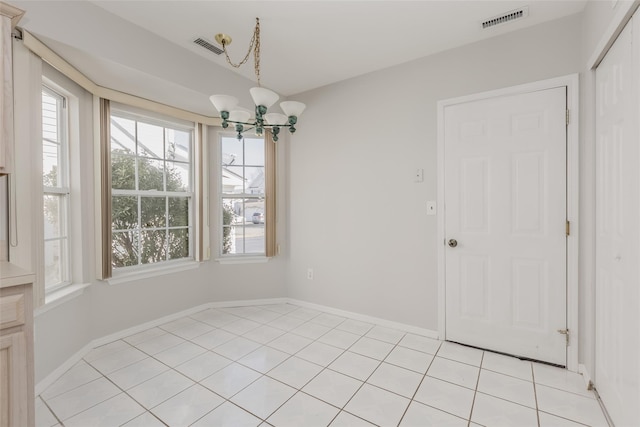 unfurnished dining area with visible vents, a chandelier, and baseboards