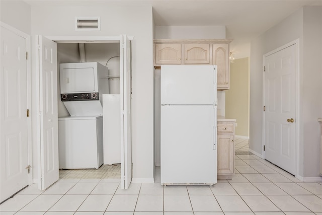 laundry room with laundry area, light tile patterned floors, visible vents, and stacked washer and dryer