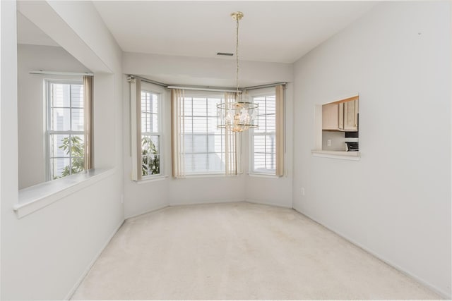 unfurnished dining area with visible vents, a chandelier, and carpet flooring