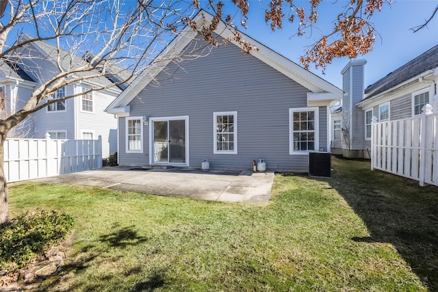 back of house featuring central air condition unit, a patio area, fence, and a lawn