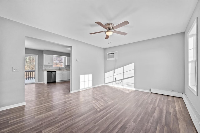 unfurnished living room with dark hardwood / wood-style floors, sink, and a baseboard heating unit