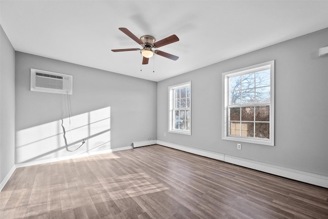 spare room with ceiling fan, a baseboard radiator, a wall mounted air conditioner, and hardwood / wood-style floors